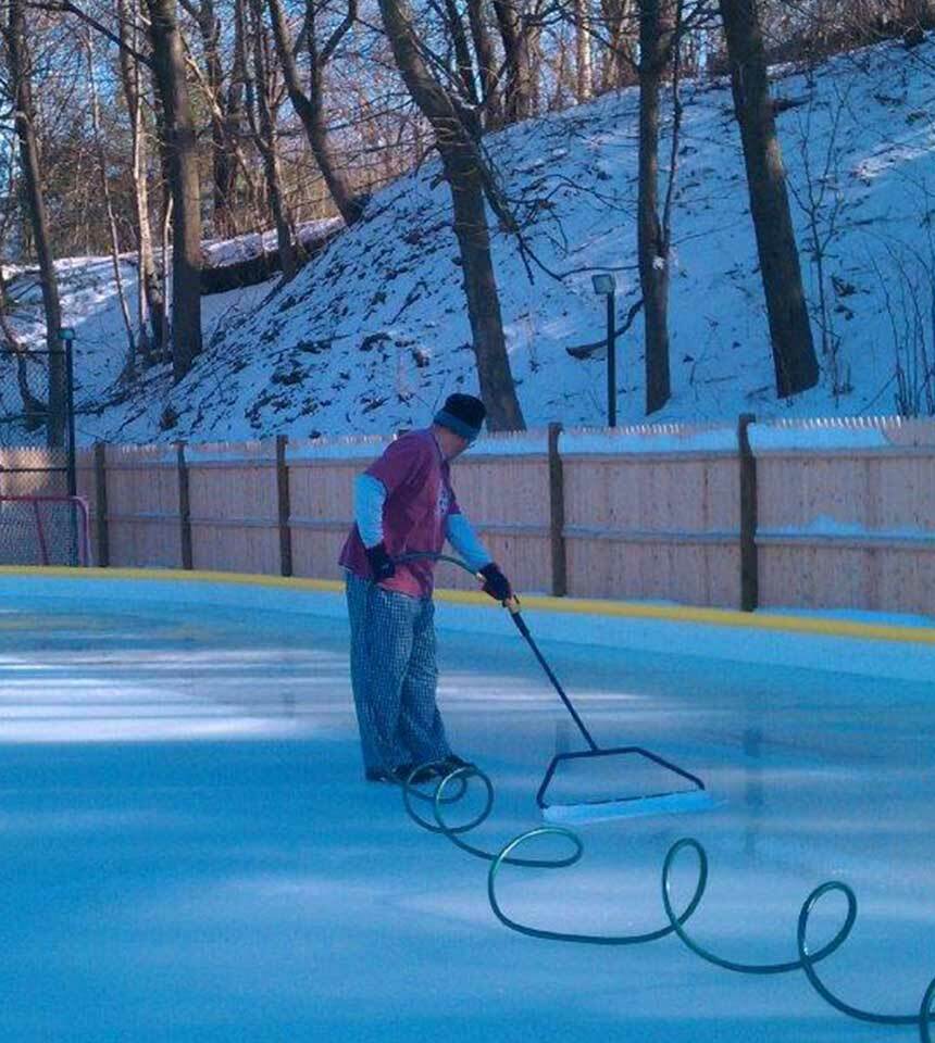 Man smoothing an ice rink surface with a 32" NiceIce™ Resurface