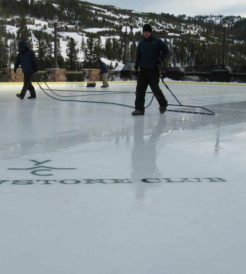 A team of people smoothing an ice rink surface with a 52" NiceIce™ Resurfacer