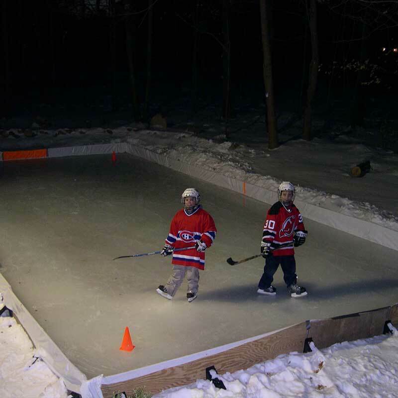 Kids playing in a backyard rink built using the Rink in a Box kit