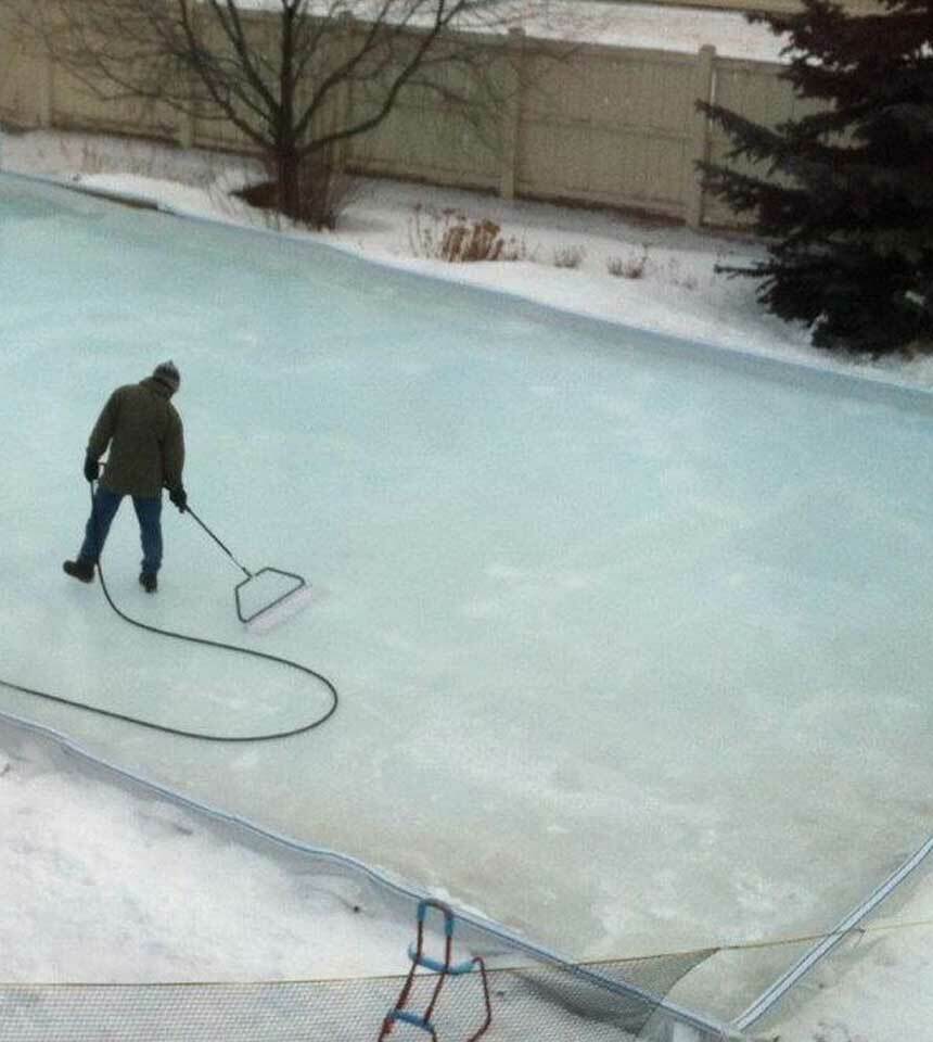 Man smoothing an ice rink surface with a 32" NiceIce™ Resurfacer